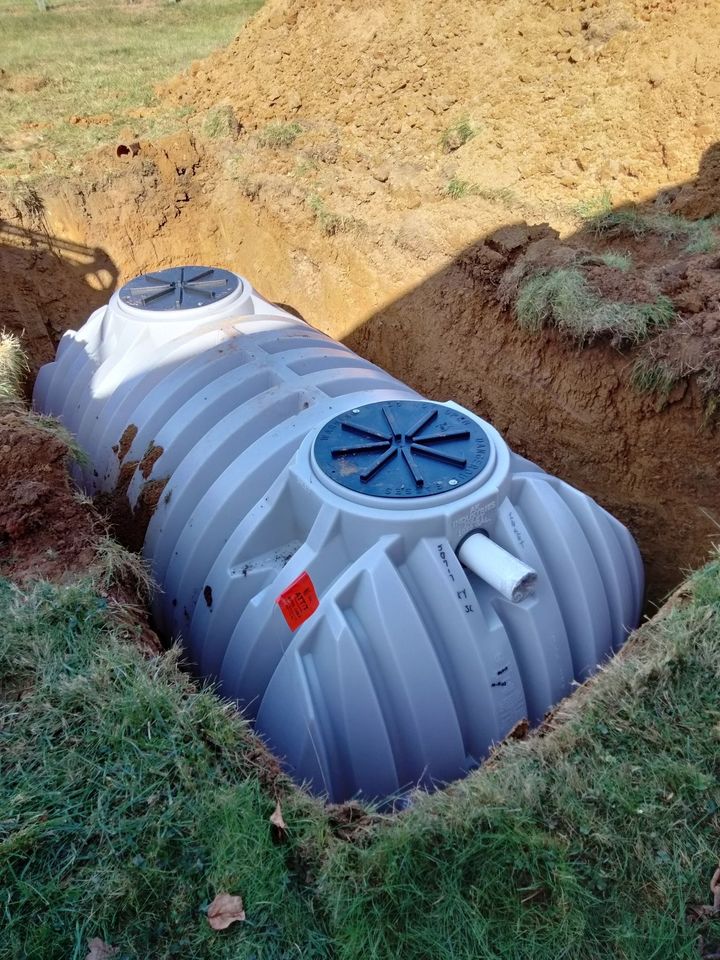 a septic tank is sitting in a hole in the ground .