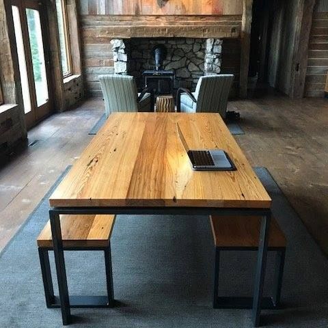 A reclaimed wooden table with a laptop on it in a living room.