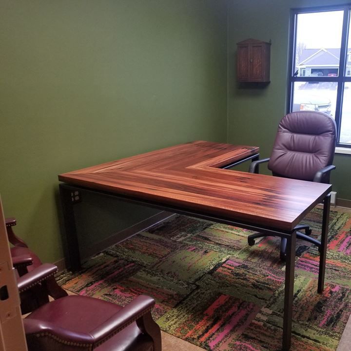 A custom wooden desk and chair in a room with green walls