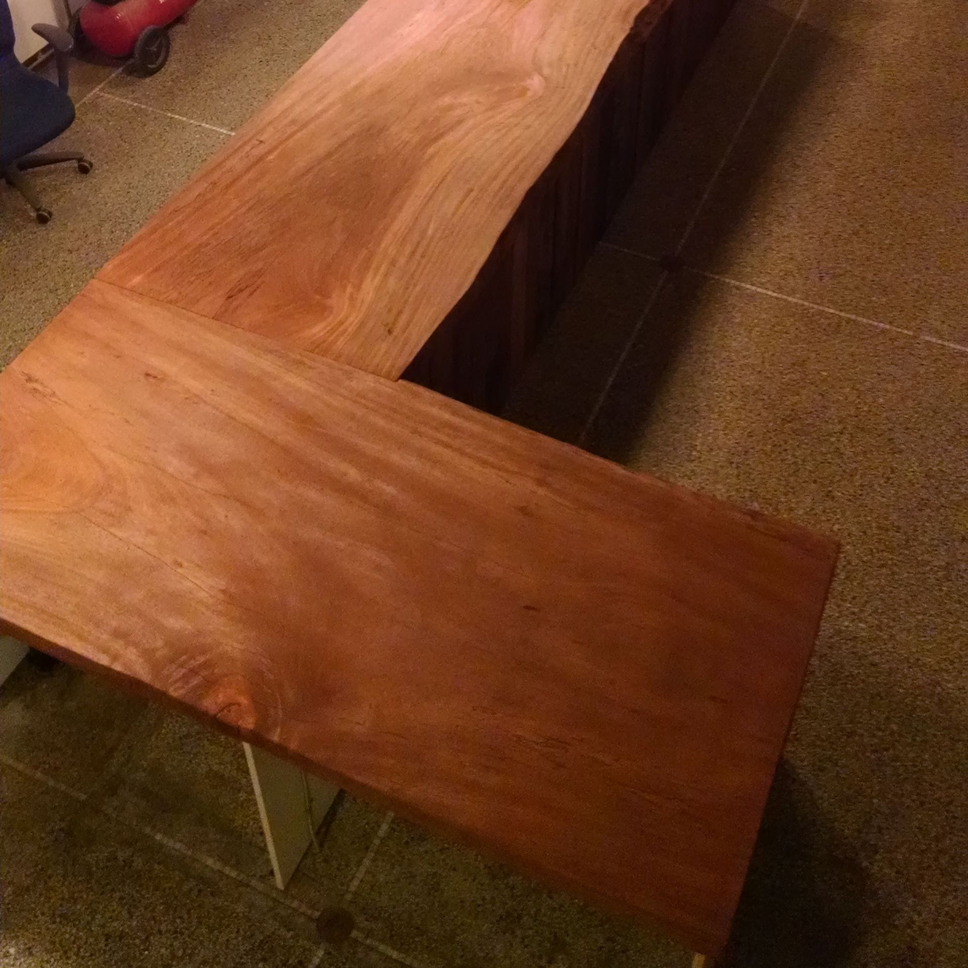 A repurposed wooden table with a chair in the background