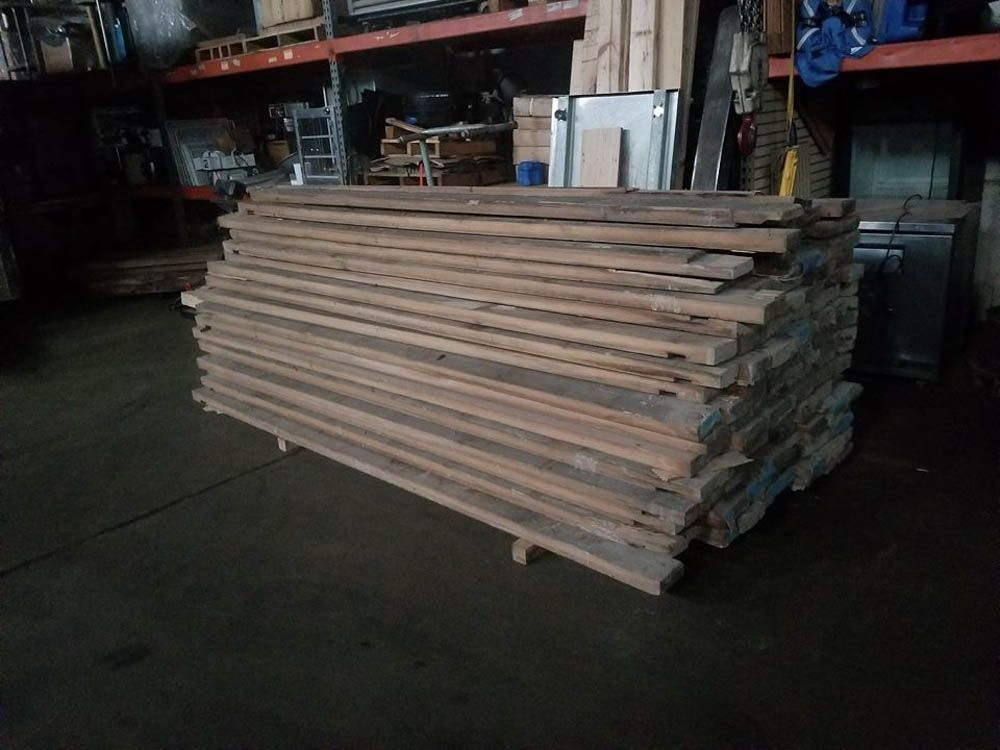 A pile of wood is sitting on the ground in a warehouse.