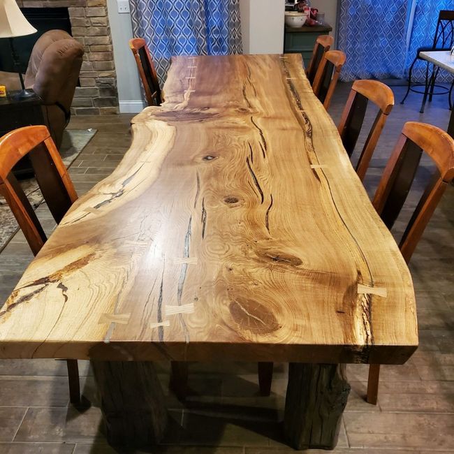 A long reclaimed wooden table with chairs in a living room
