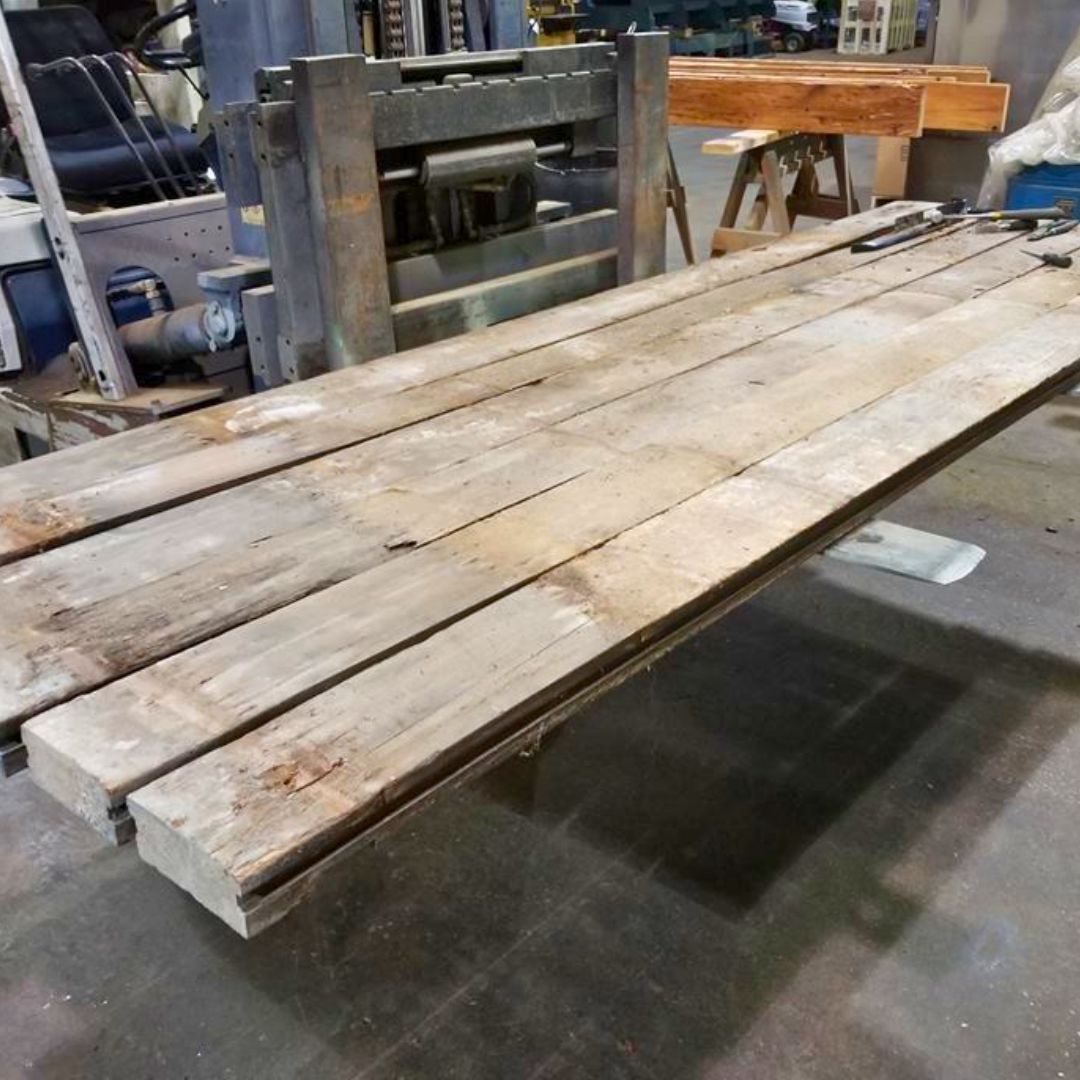 A wooden table with a forklift in the background