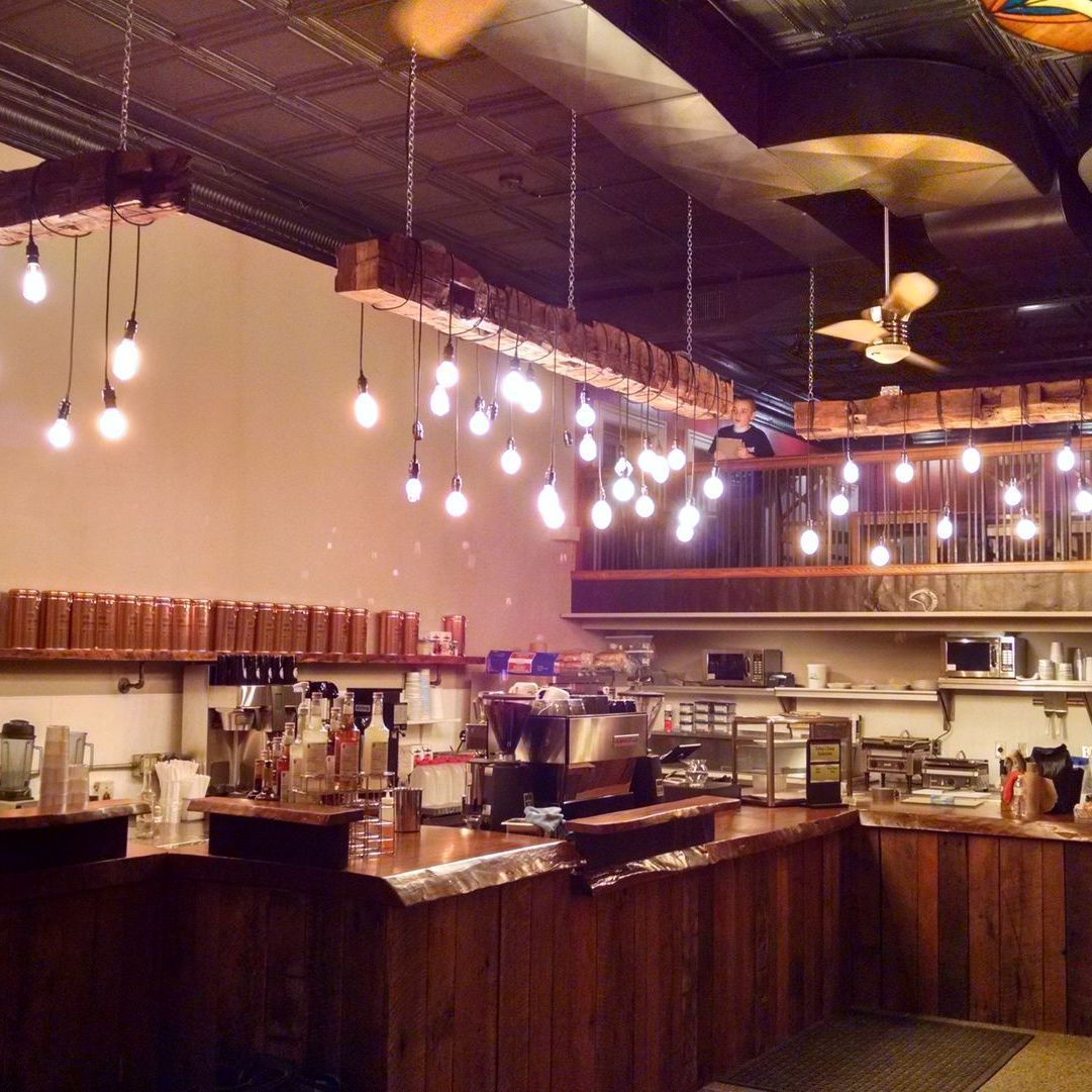 A restaurant with custom wood beams hanging from the ceiling