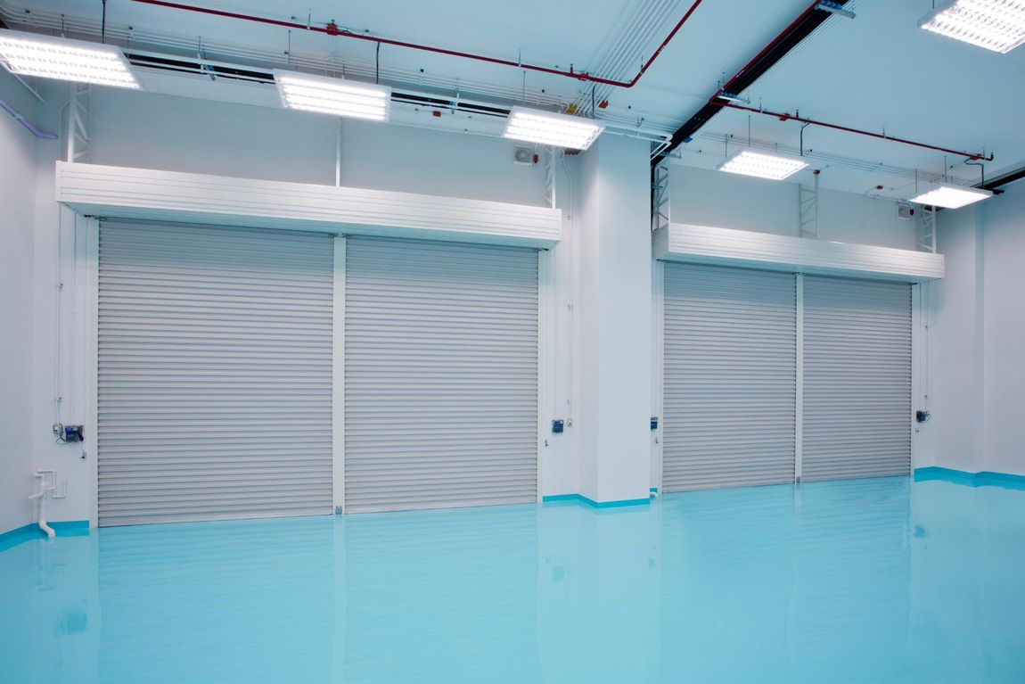 A large empty room with a blue floor and white walls.