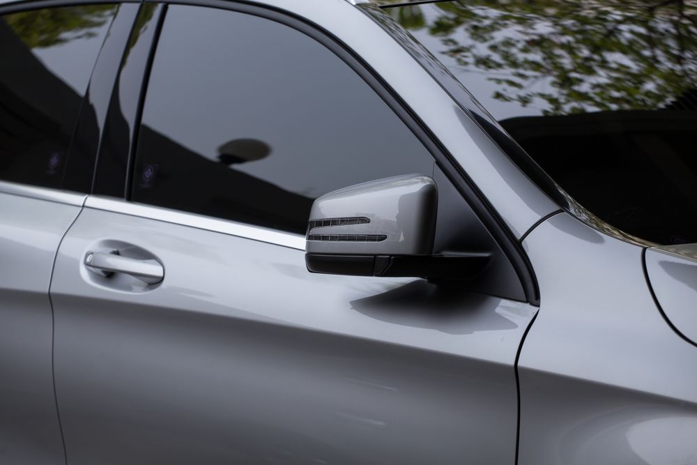 A Silver Car With A Black Side Mirror Is Parked In A Parking Lot — Tint a Car Sunshine Coast In Buderim, QLD