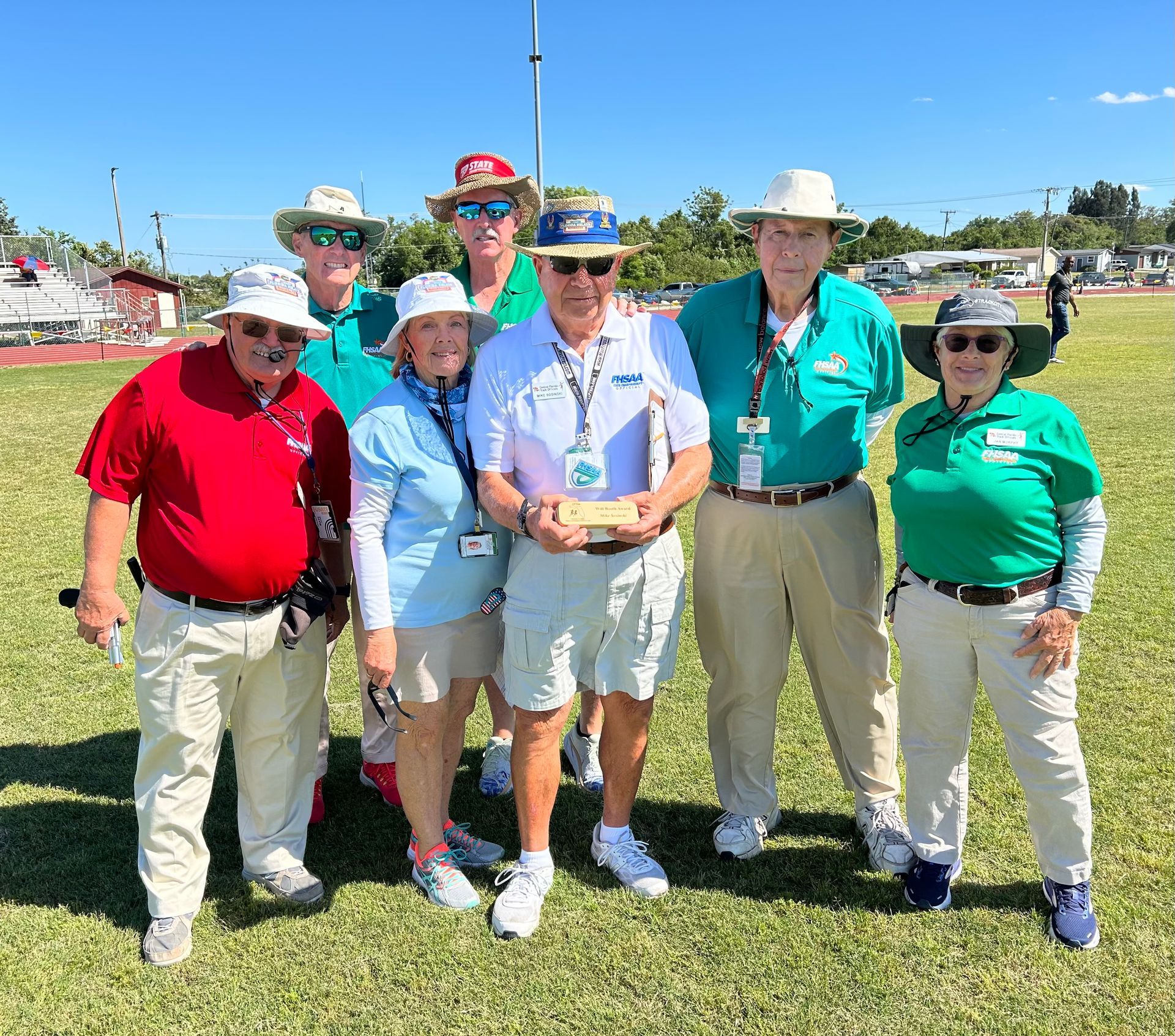 A group of people are posing for a picture in a field.