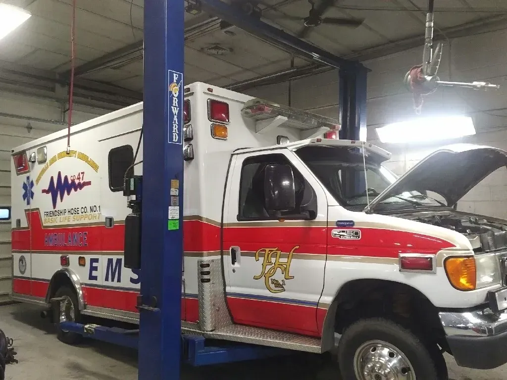 Ambulance on a Lift Inside a Garage | Hippensteel Auto Inc.