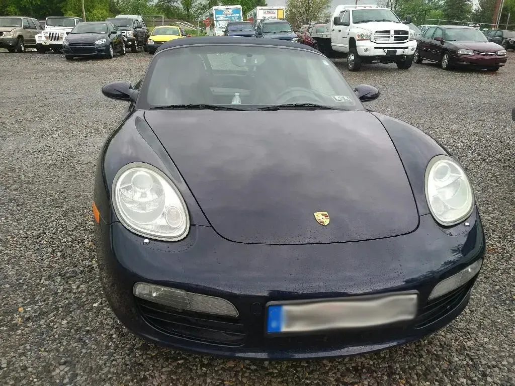 Dark Blue Porsche Boxster Convertible Parked Outdoors in a Gravel Lot | Hippensteel Auto Inc.