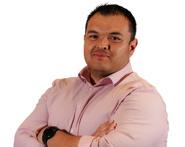 A man in a pink shirt with his arms crossed