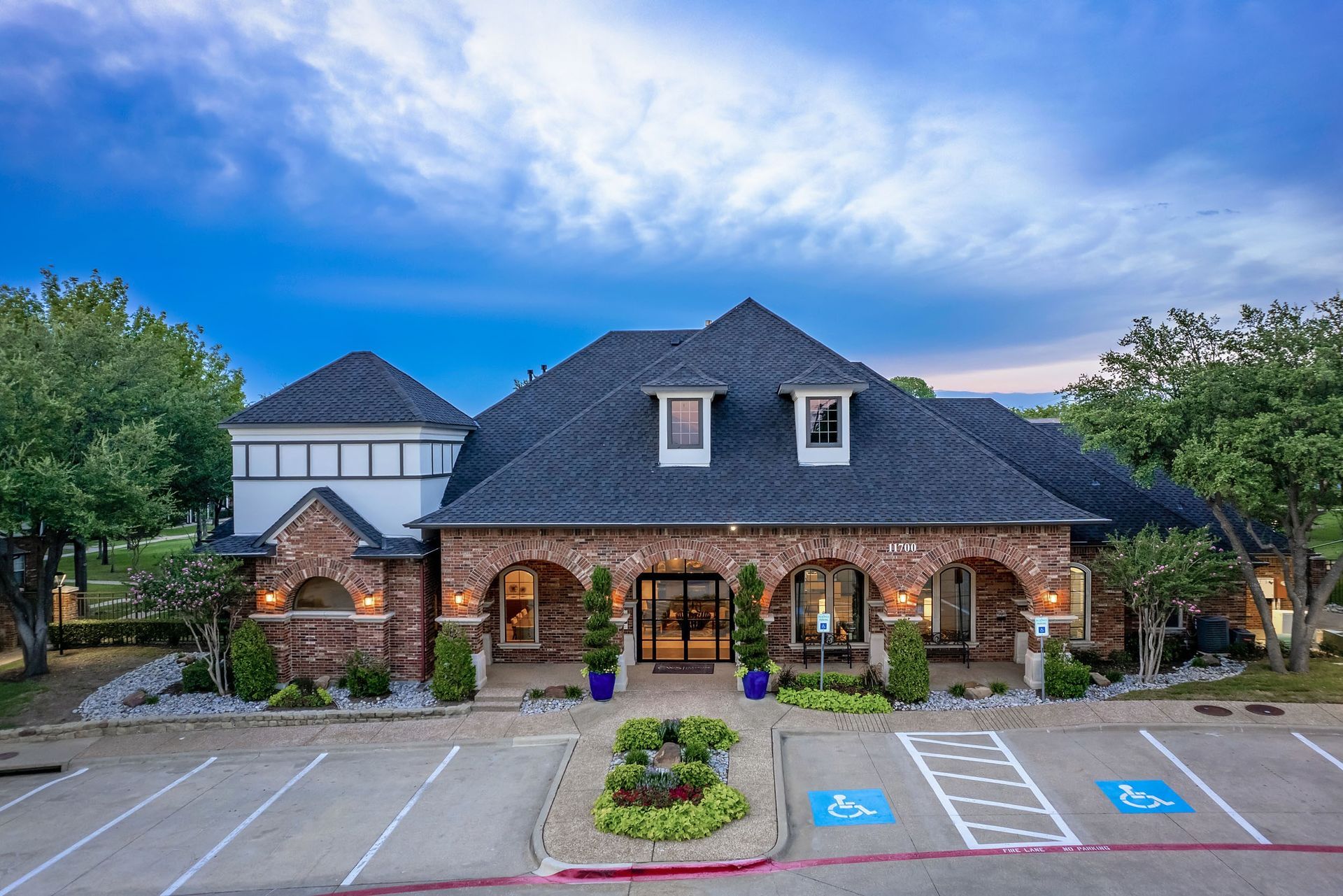 Marquis at Stonebriar leasing office building exterior view with parking spot in Frisco, TX.