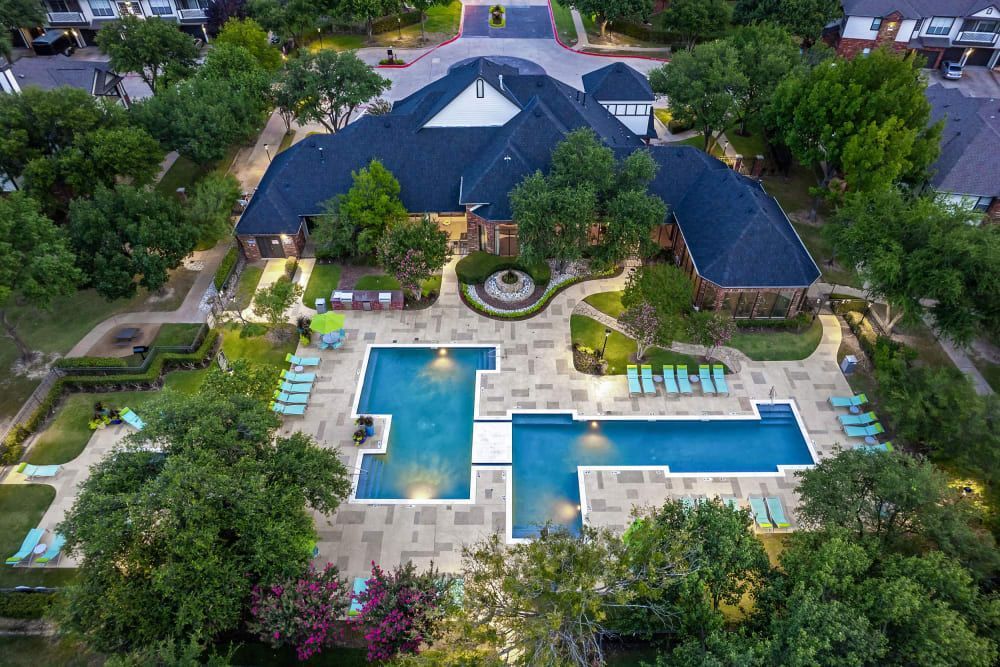 An aerial view of a large swimming pool surrounded by trees at Marquis at Stonebriar in Frisco, TX.