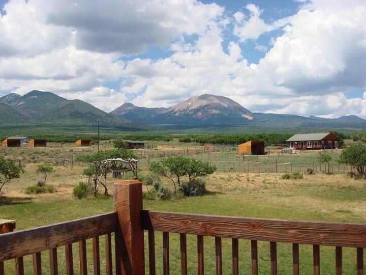 A view of a mountain range from a wooden deck