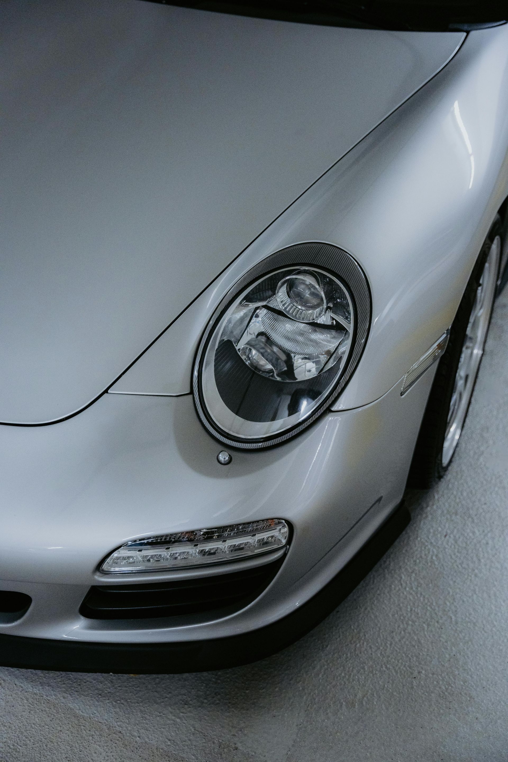 A silver sports car is parked in a garage