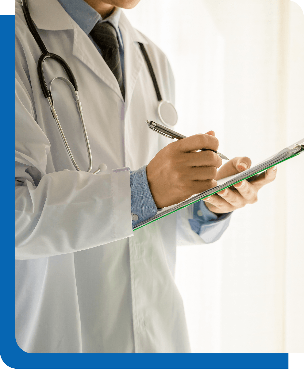 A doctor is writing on a clipboard with a pen.