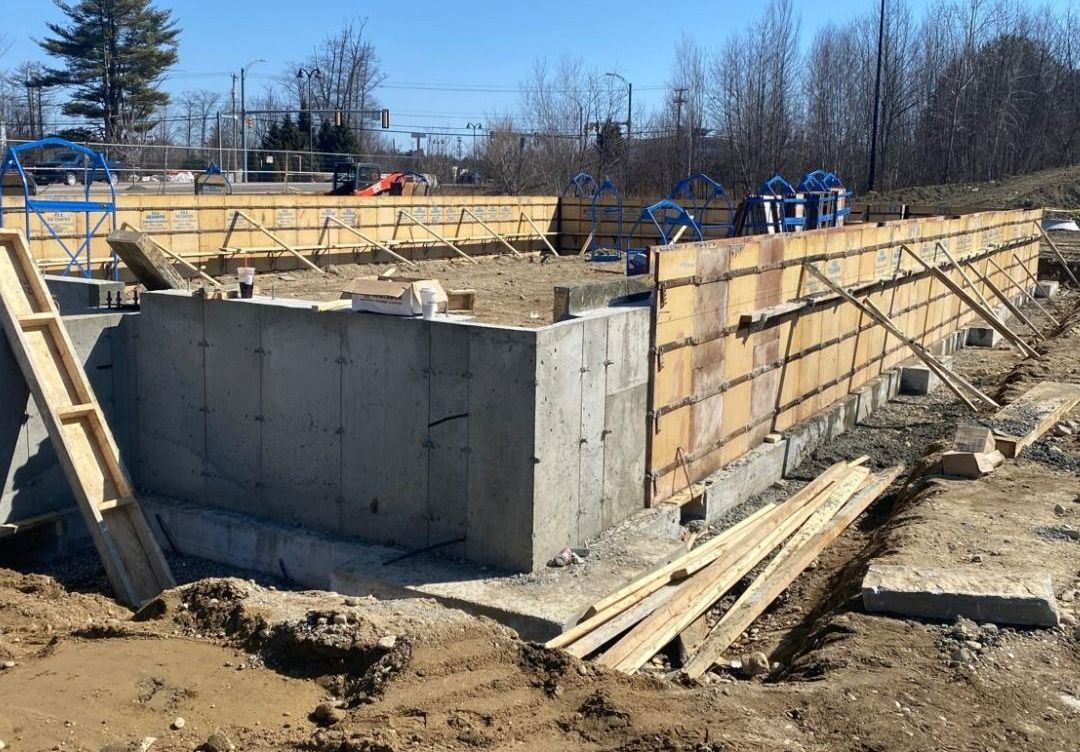 A concrete wall is being built on a construction site.