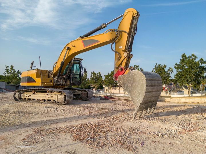 A yellow excavator is working on a construction site.