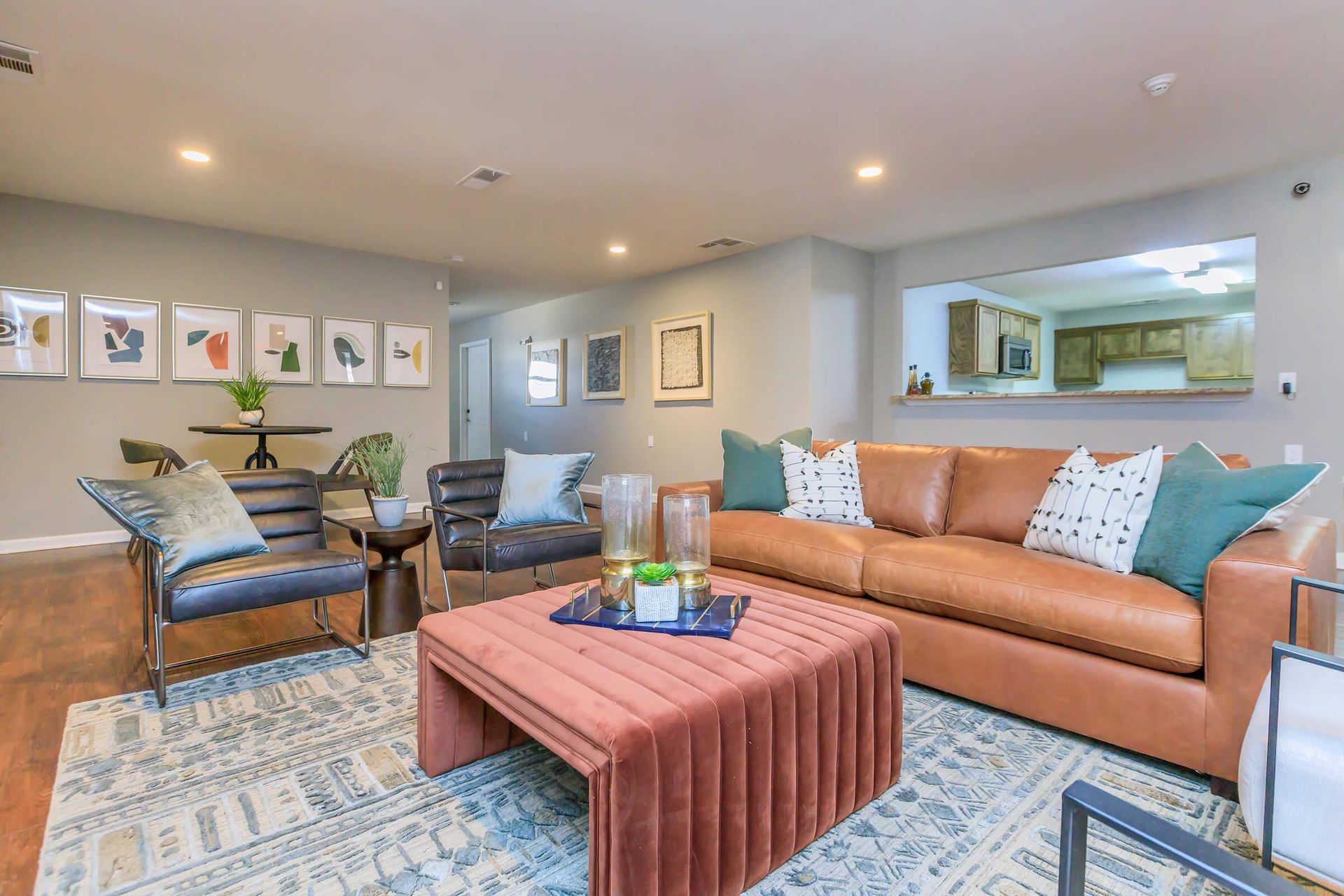 Living room with brown leather sofa, patterned rug, and colorful artwork on the wall.