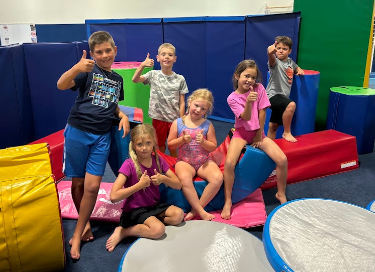 A group of children are posing for a picture in a gym.