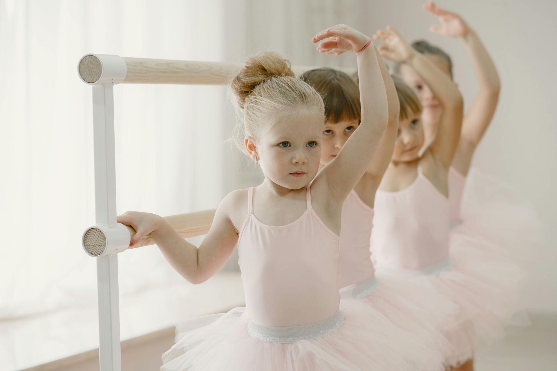A group of young girls are practicing ballet in a dance studio.