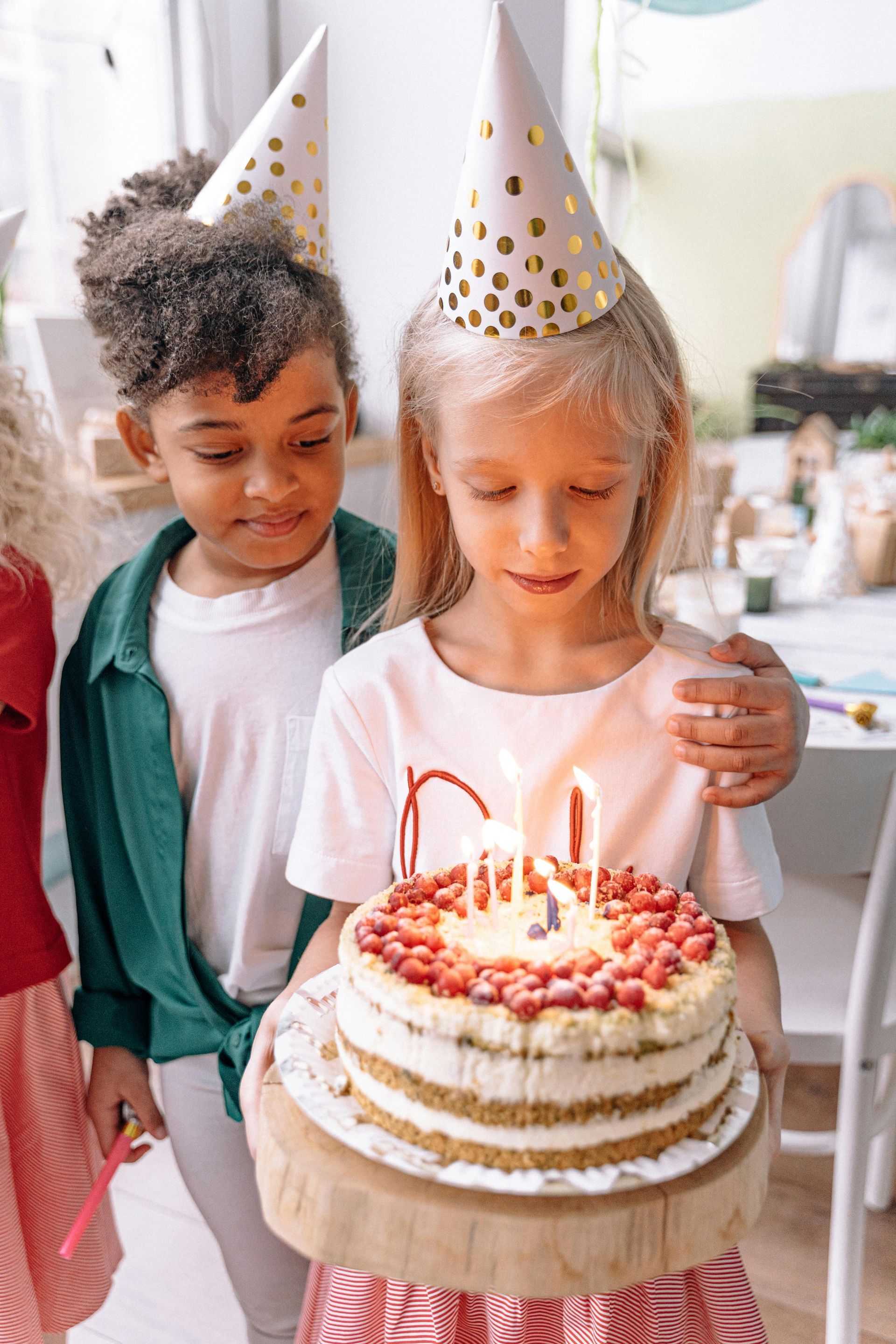 A little girl is blowing out candles on a birthday cake.