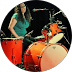 A woman is playing drums in a circle.