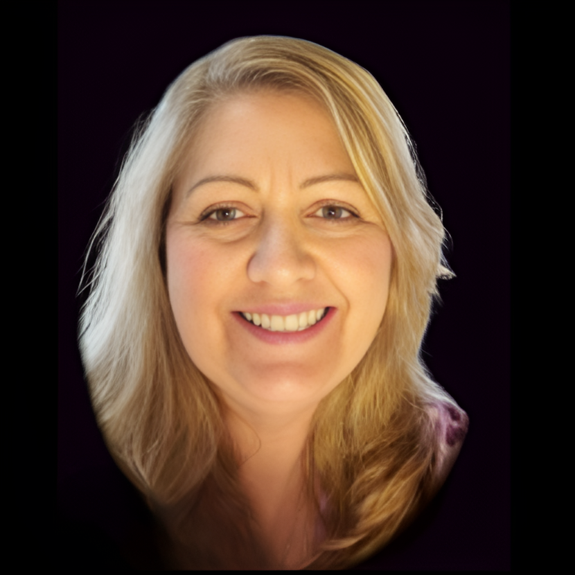 Blonde woman smiling, with fair skin and eyes. She wears a pink top, against a black background.