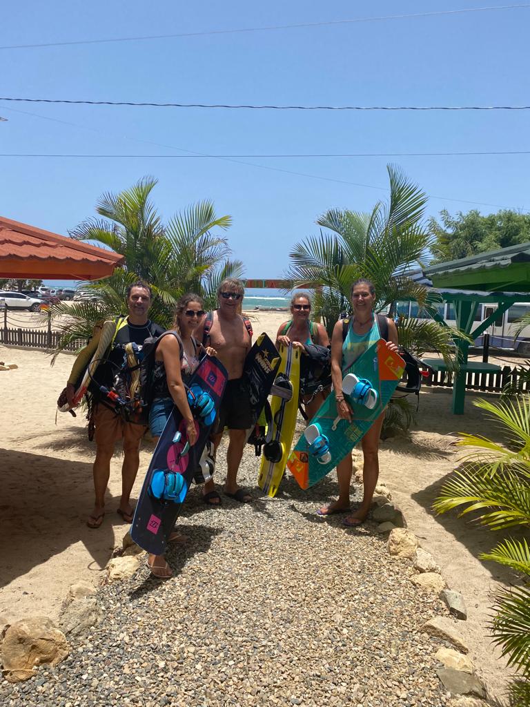 A group of people standing next to each other on a beach holding surfboards.