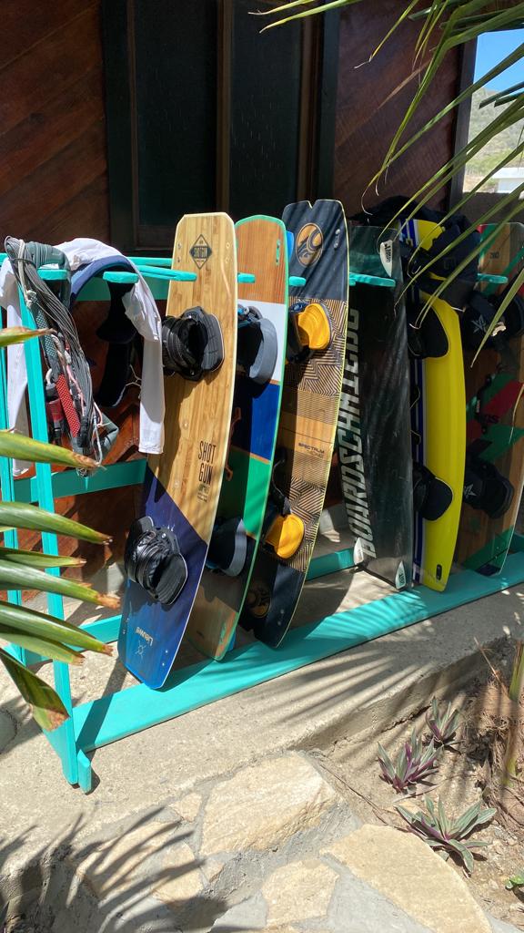 A bunch of surfboards are hanging on a rack.