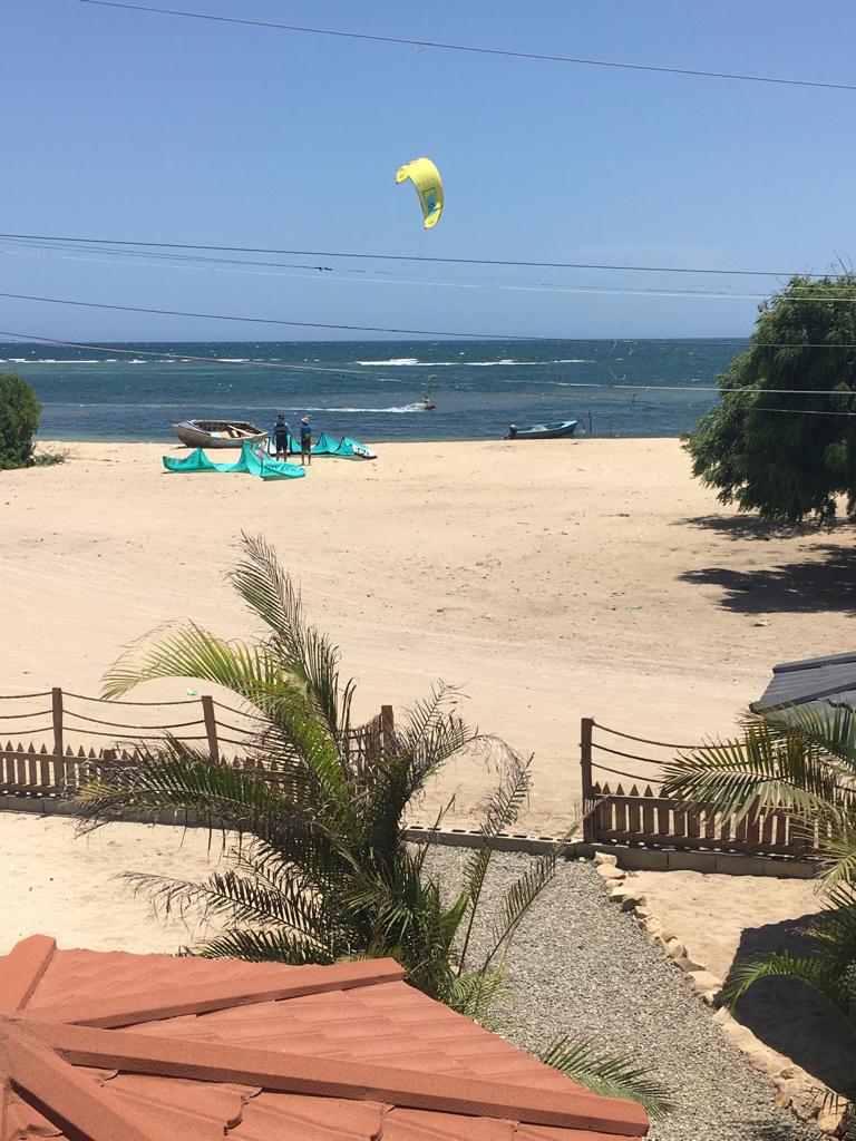 A kite is flying over a sandy beach near the ocean