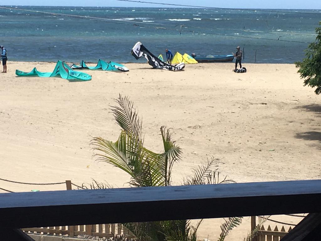 A view of a beach from a balcony with kites on it