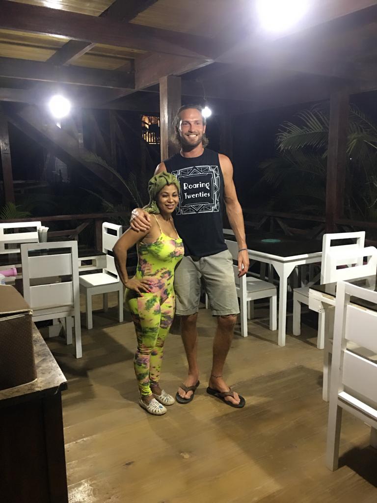 A man and a woman are standing next to each other on a porch.