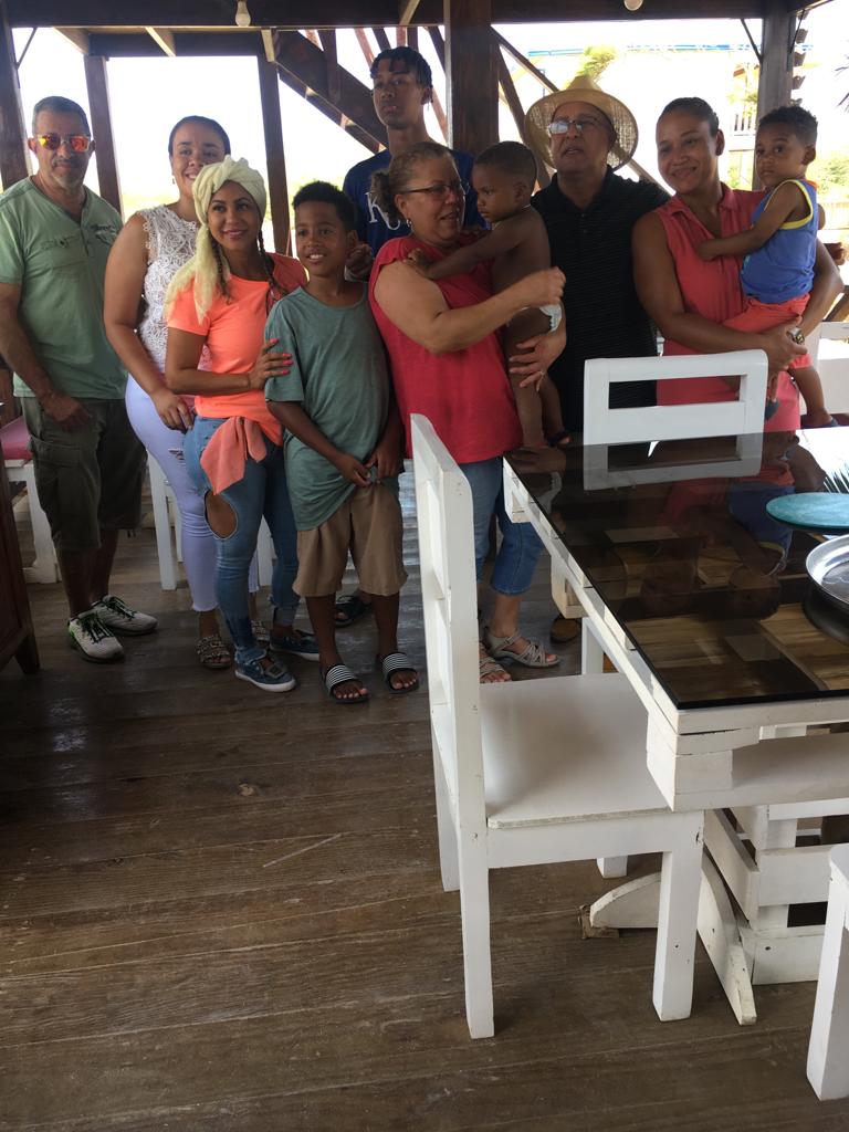 A group of people posing for a picture in front of a table and chairs