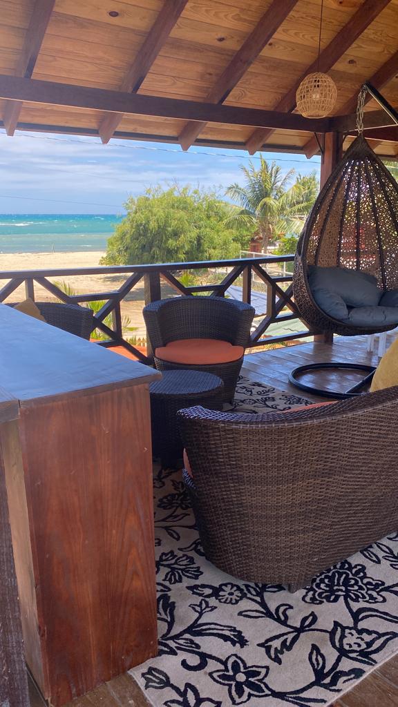 A living room with wicker furniture and a view of the ocean.