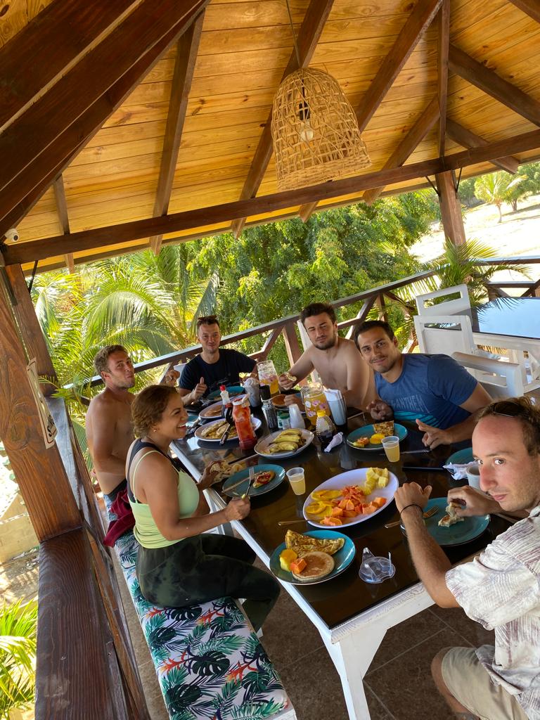 A group of people are sitting around a table eating food.