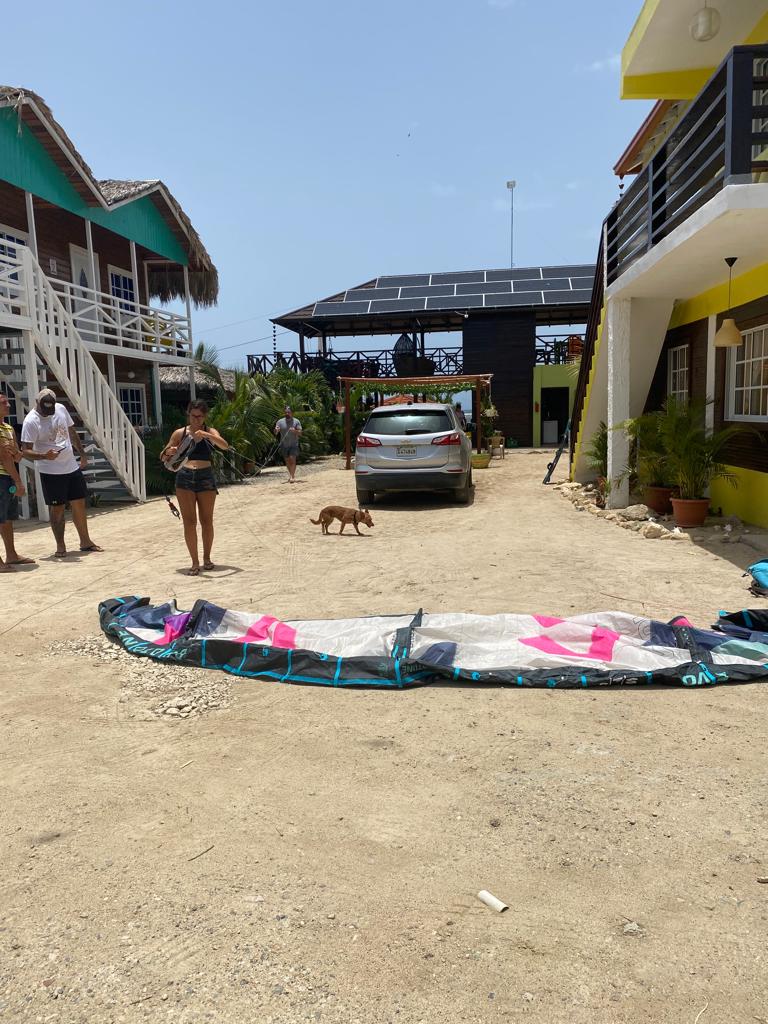 A group of people standing in front of a building with a car parked in the background