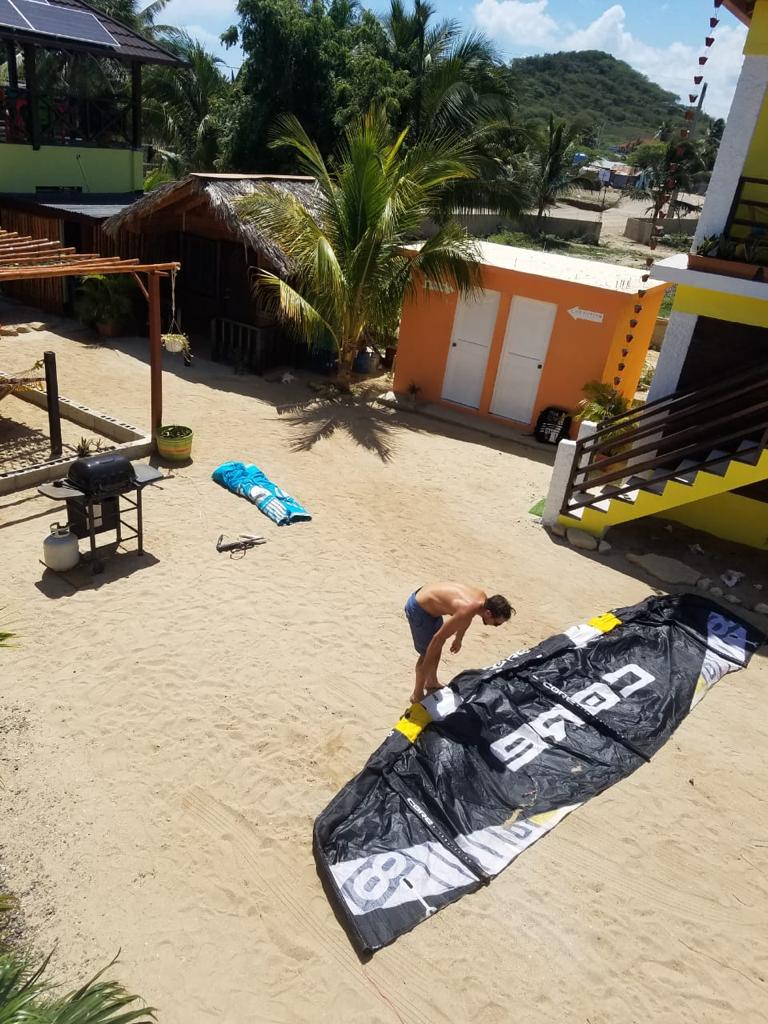 A man is holding a large black tarp that says cabs on it