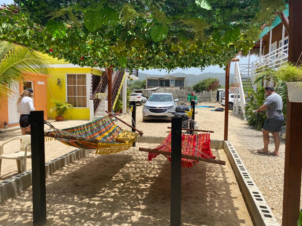 A man is standing next to a hammock in front of a building.