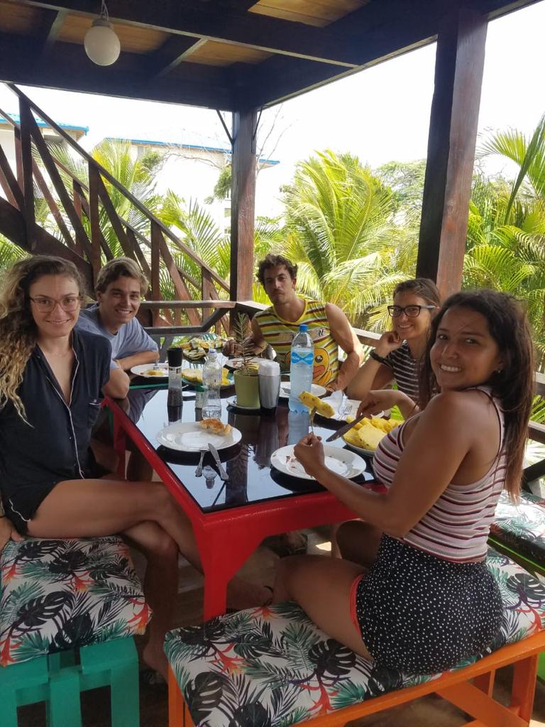 A group of people are sitting around a table eating food.
