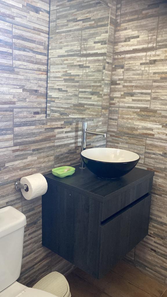 A bathroom with a sink , toilet and mirror.
