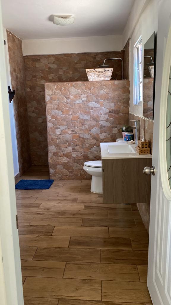 A bathroom with a toilet , sink , and shower.