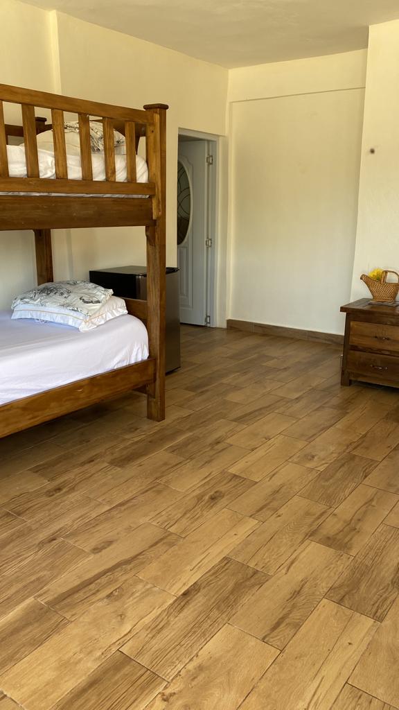 A bedroom with two bunk beds and a wooden floor.