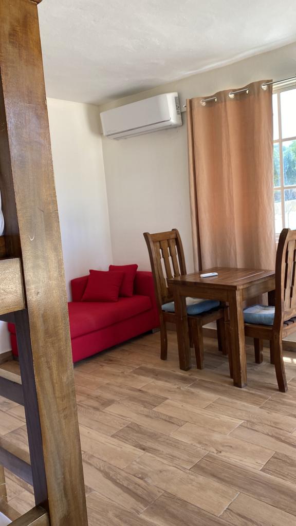 A living room with a red couch , table and chairs.