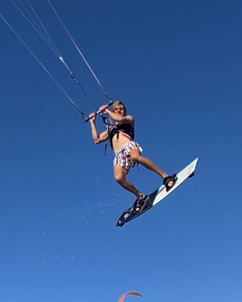 A person is flying through the air on a surfboard