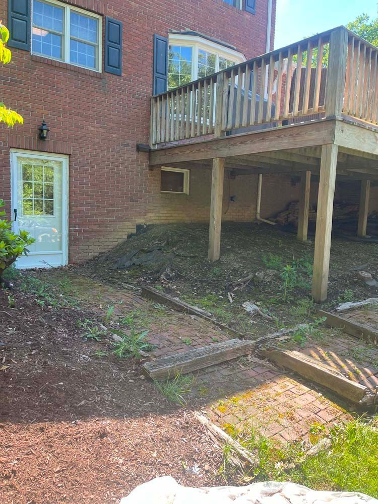 A brick house with a wooden deck in the backyard.