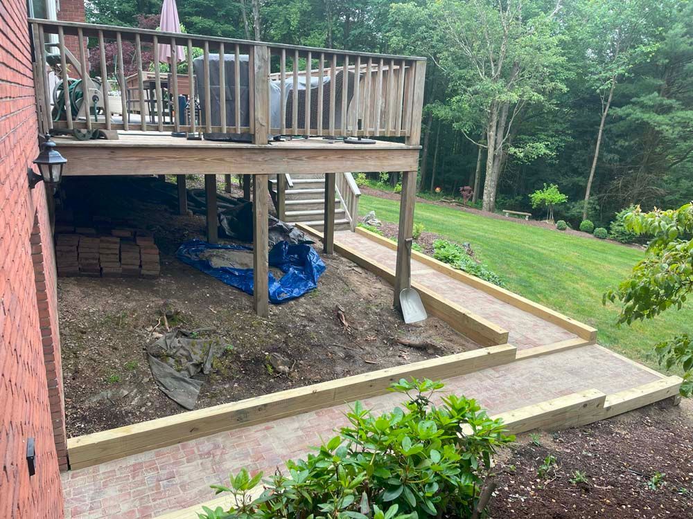 A wooden deck is being built in the backyard of a house.