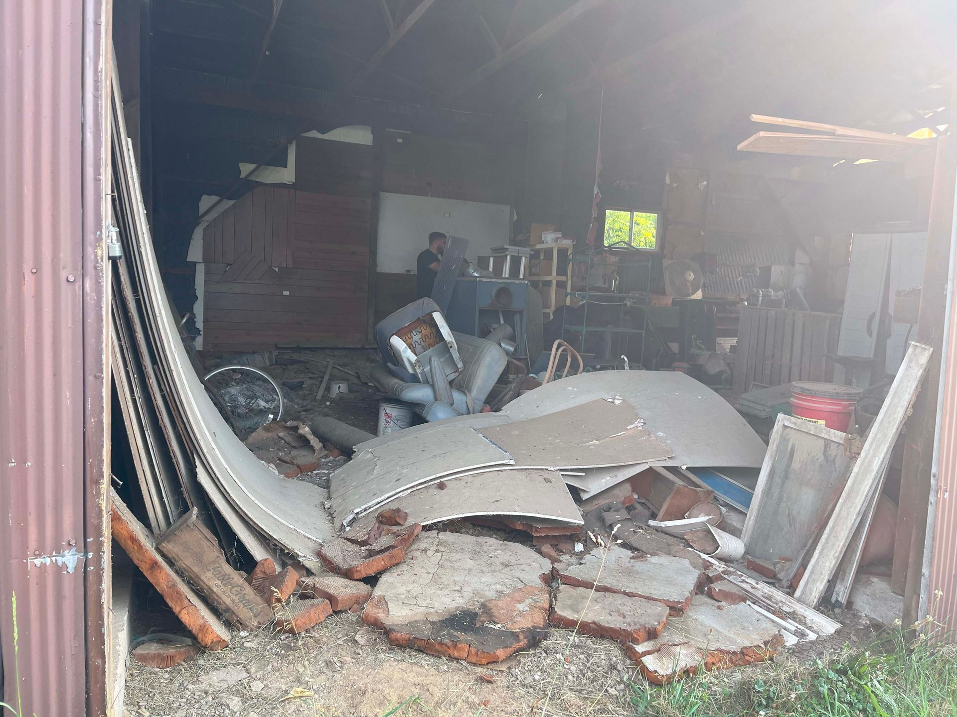 A pile of junk is sitting inside of a garage.