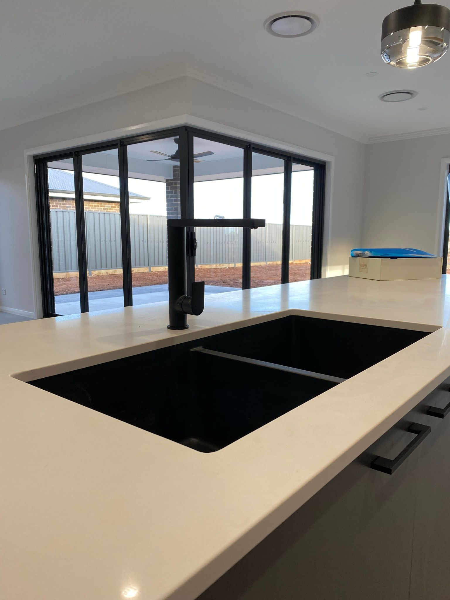 Side View of Black Kitchen Sink and Tap Water in The Kitchen — Kitchen Renovations in Dubbo, QLD