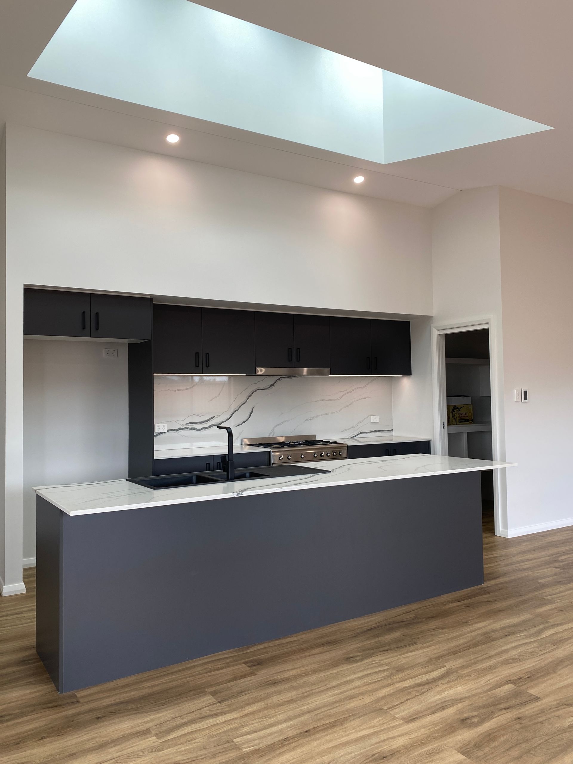 White Kitchen With Black Sink and Faucet — Kitchen Renovations in Dubbo, QLD