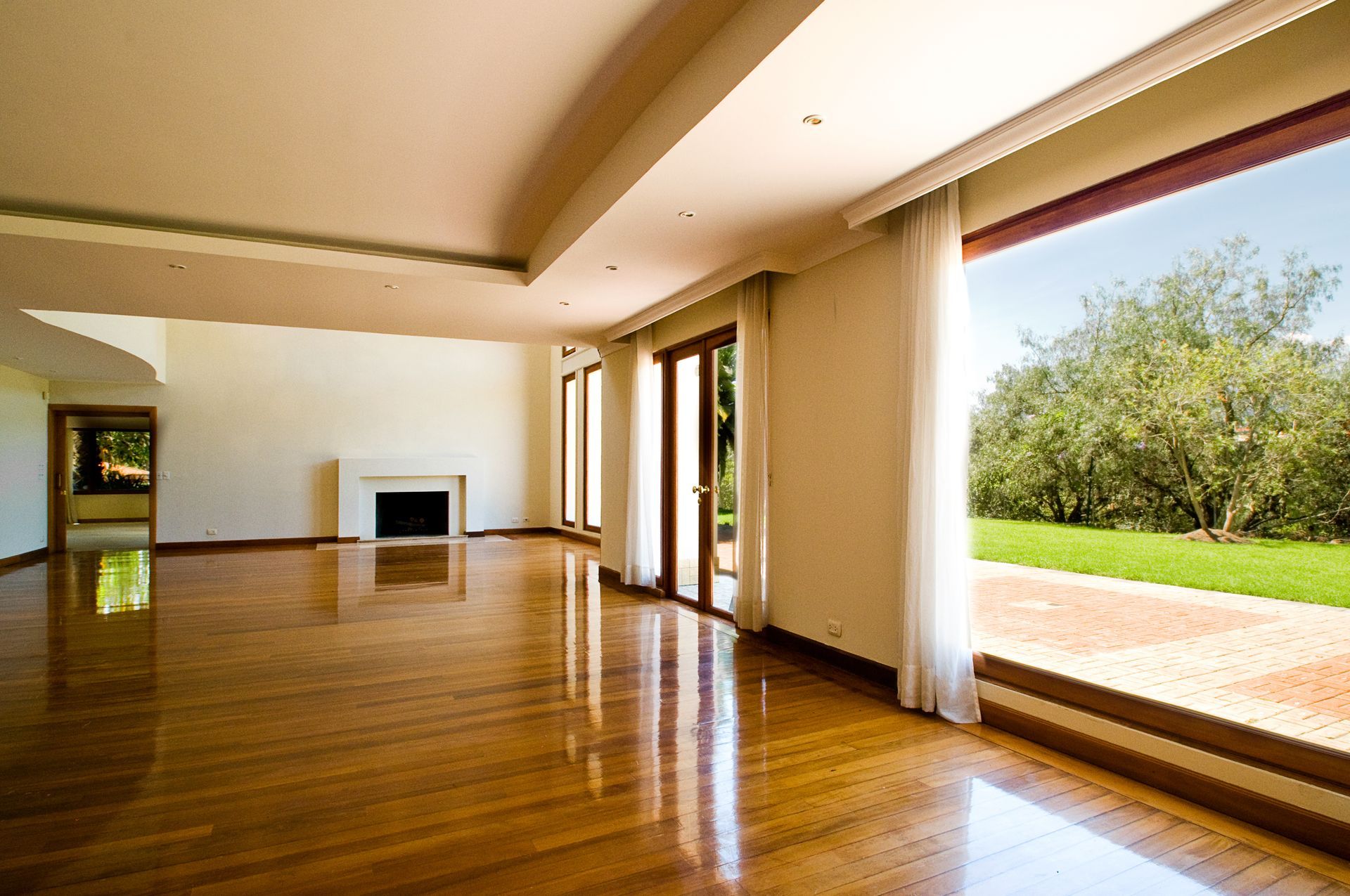 An empty living room with hardwood floors and a fireplace